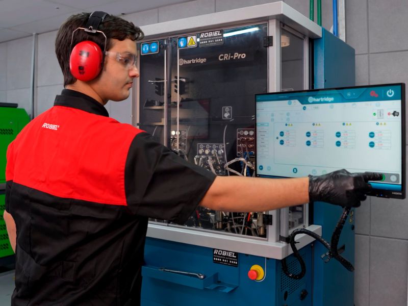 Técnico da ROBIEL realizando diagnóstico e regulagem em motor diesel com equipamento de teste eletrônico, ambiente de laboratório industrial, fotografia realista